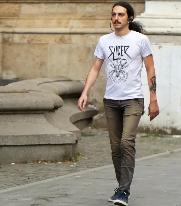 Een man wandelt ontspannen door de stad in gewone dagelijkse kleding, zonder sportoutfit.